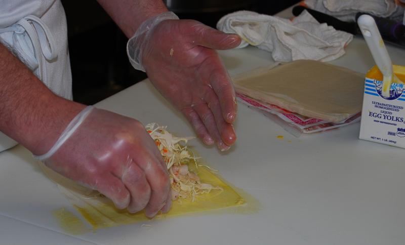 Those disembodied hands belong to Big Fish Grill owner Norm Sugrue. His gloved hands are making eggrolls for one of his cooking classes. He is always on the lookout for potential cross-contamination. After all, it's his livelihood that's at stake. BOB YESBEK PHOTO